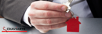 Homem com chave na mão. O porta-chaves tem uma casa vermelha. Inclui ainda o logótipo da Chaviarte, empresa especializada em chaves e fechaduras.
